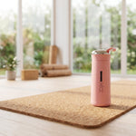 Pink water bottle with a blurred indoor background